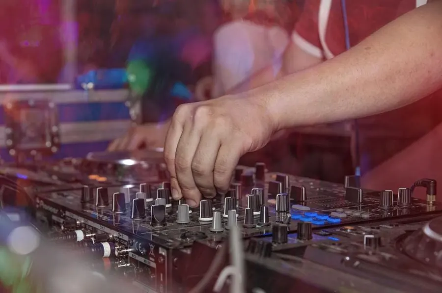 DJ en consola con luz neón rosa